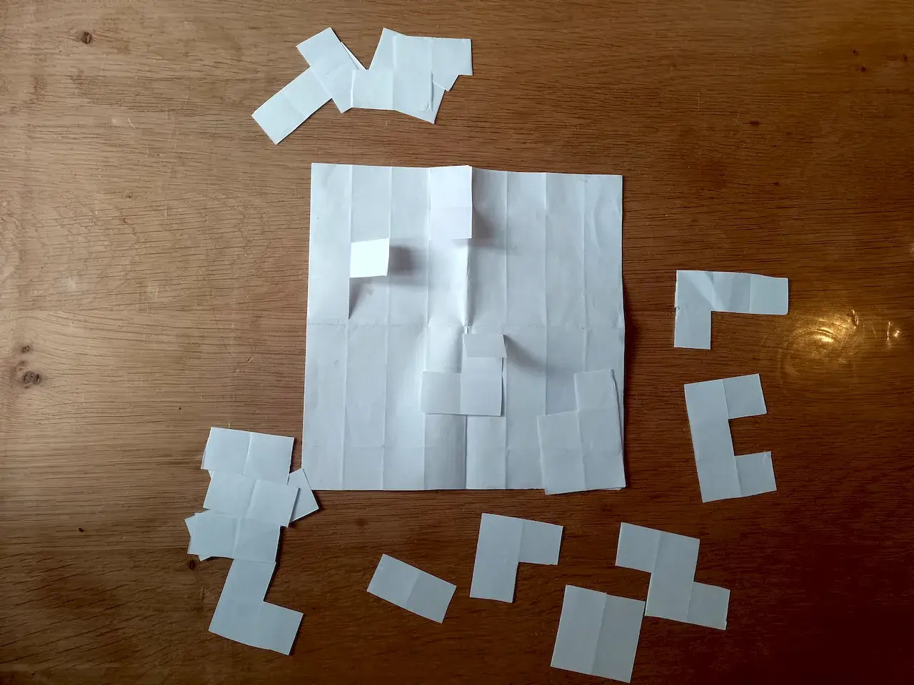 A paper prototype I made for the game. This showed me that the idea is solid, but “folding” is a bit flimsy a mechanic. As you see, I never even got so far as to draw ICONS on those pieces.